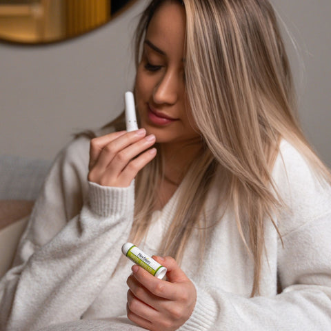A woman holding Herbion Nasal Inhaler